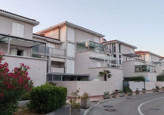 Contemporary apartment complex with outdoor greenery during twilight.